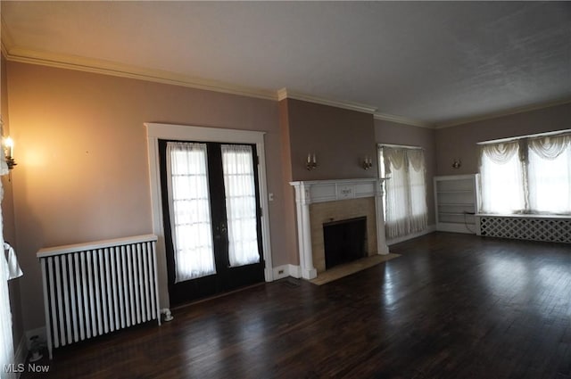 519 E Lincoln Way, Lisbon, OH 44432 - unfurnished living room featuring radiator, a fireplace with flush hearth, wood finished floors, crown molding, and french doors