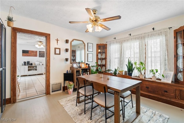 794 Ranney St, Akron, OH 44310 - dining space featuring a ceiling fan, a textured ceiling, arched walkways, and light wood-style flooring