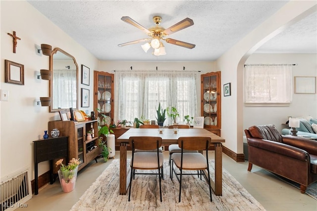 794 Ranney St, Akron, OH 44310 - dining space featuring arched walkways, ceiling fan, a textured ceiling, and baseboards