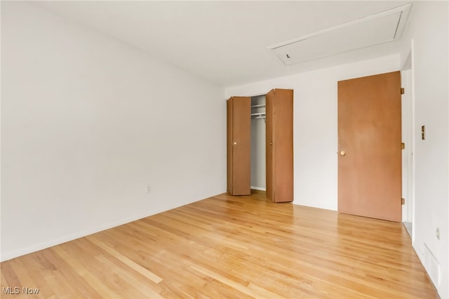 36948 S Lake Shore Blvd, Eastlake, OH 44095 - unfurnished bedroom featuring attic access, light wood-style floors, and a closet