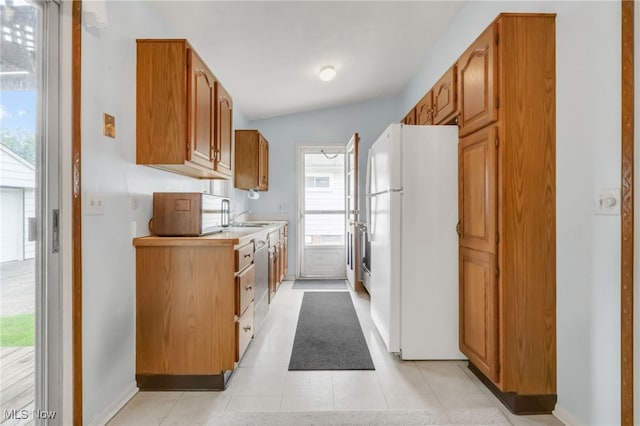 36948 S Lake Shore Blvd, Eastlake, OH 44095 - kitchen featuring freestanding refrigerator, light countertops, dishwashing machine, baseboards, and brown cabinetry