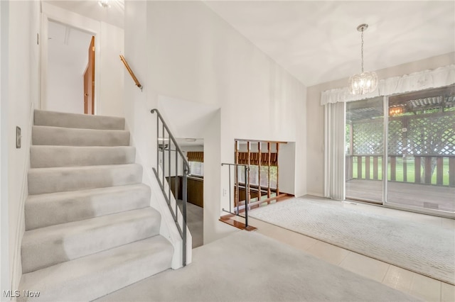 36948 S Lake Shore Blvd, Eastlake, OH 44095 - stairway with a chandelier, high vaulted ceiling, and tile patterned floors
