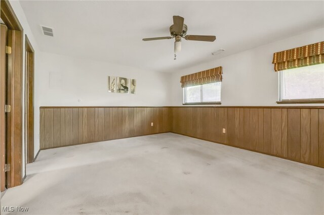36948 S Lake Shore Blvd, Eastlake, OH 44095 - spare room with light colored carpet, ceiling fan, wainscoting, and wood walls