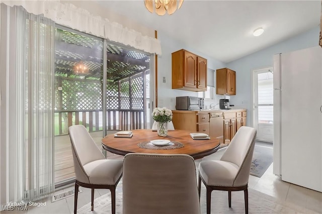36948 S Lake Shore Blvd, Eastlake, OH 44095 - dining area featuring lofted ceiling, light tile patterned floors, and a chandelier