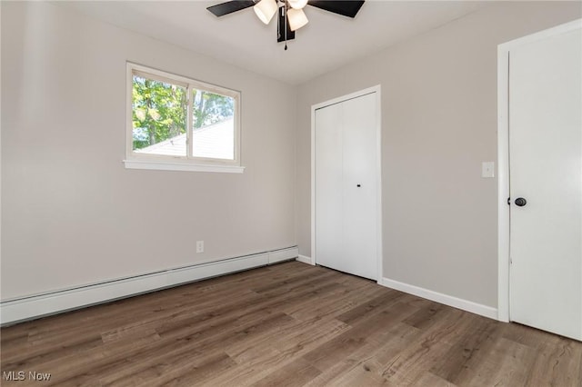 1294 E 345th St, Eastlake, OH 44095 - unfurnished bedroom with baseboard heating, wood finished floors, a closet, baseboards, and ceiling fan