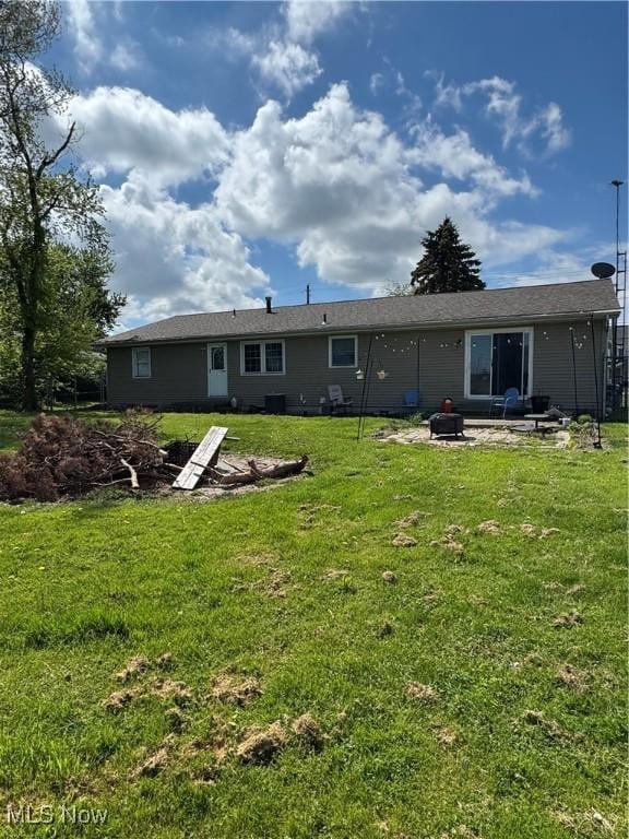 1009 Bogart Rd, Huron, OH 44839 - back of house featuring an outdoor fire pit, a lawn, a patio, and central AC unit