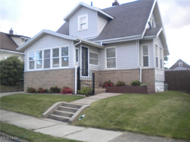 161 25th St NW, Barberton, OH 44203 - view of front of home with brick siding, roof with shingles, and a chimney