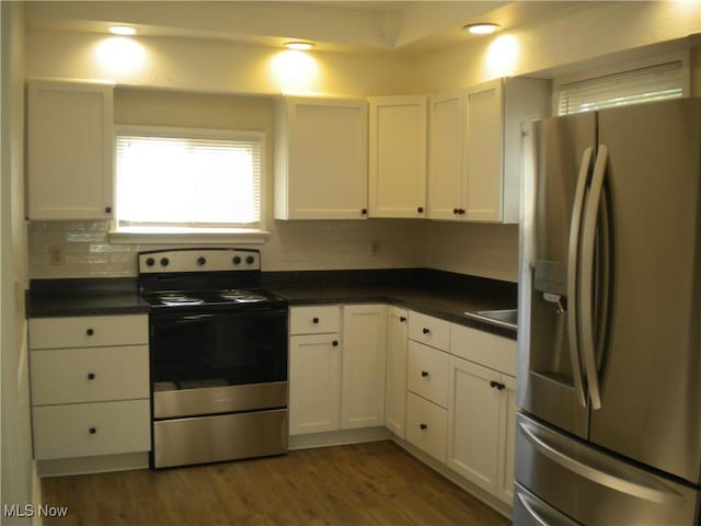 161 25th St NW, Barberton, OH 44203 - kitchen with stainless steel appliances, dark countertops, backsplash, and white cabinetry