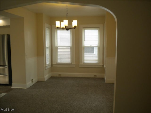 161 25th St NW, Barberton, OH 44203 - unfurnished room featuring arched walkways, a chandelier, and carpet flooring