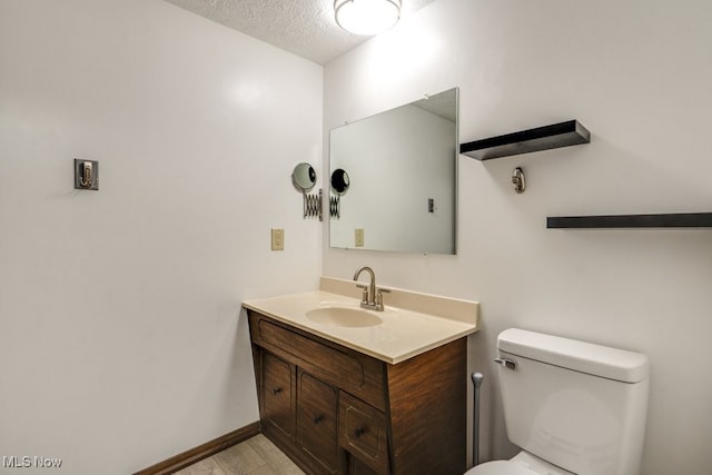 2377 Ansley St, Alliance, OH 44601 - bathroom featuring vanity, toilet, a textured ceiling, and wood finished floors