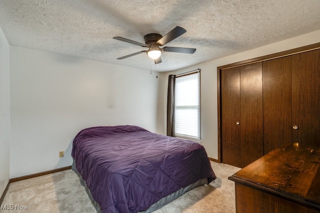 2377 Ansley St, Alliance, OH 44601 - bedroom with light colored carpet, baseboards, a closet, a textured ceiling, and ceiling fan