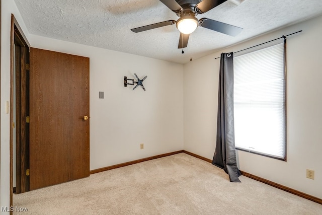 2377 Ansley St, Alliance, OH 44601 - spare room with light carpet, a textured ceiling, a ceiling fan, and baseboards