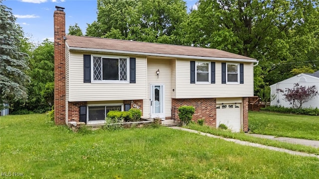 3067 Bronco Dr, Clinton, OH 44216 - split foyer home featuring a chimney, brick siding, a front lawn, and a garage