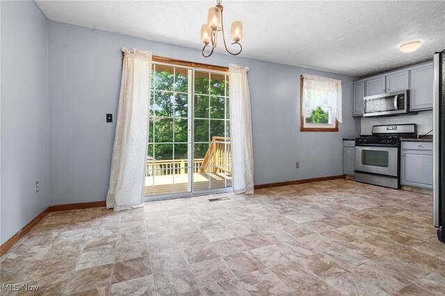 3067 Bronco Dr, Clinton, OH 44216 - kitchen featuring stainless steel appliances, a chandelier, baseboards, stone finish floors, and a textured ceiling