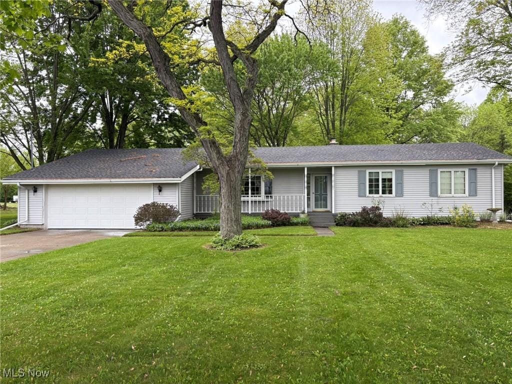 12709 Pyle S Amherst Rd, Oberlin, OH 44074 - ranch-style home featuring a porch, a front lawn, an attached garage, and driveway