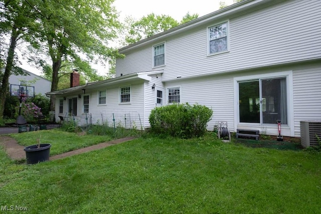 5940 Hansom Dr, Solon, OH 44139 - back of property with central air condition unit, a yard, and a chimney
