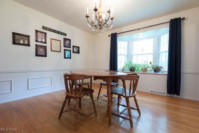 5940 Hansom Dr, Solon, OH 44139 - dining area with a chandelier, light wood-type flooring, and a wainscoted wall