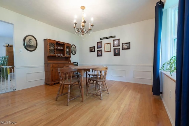 5940 Hansom Dr, Solon, OH 44139 - dining area with a chandelier, a decorative wall, light wood-style flooring, and a wainscoted wall