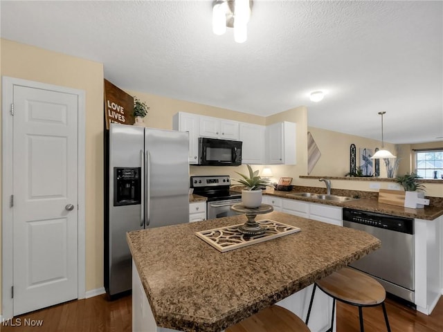6010 Turnwood Dr, Westerville, OH 43081 - kitchen with stainless steel appliances, a sink, a peninsula, white cabinetry, and dark wood finished floors