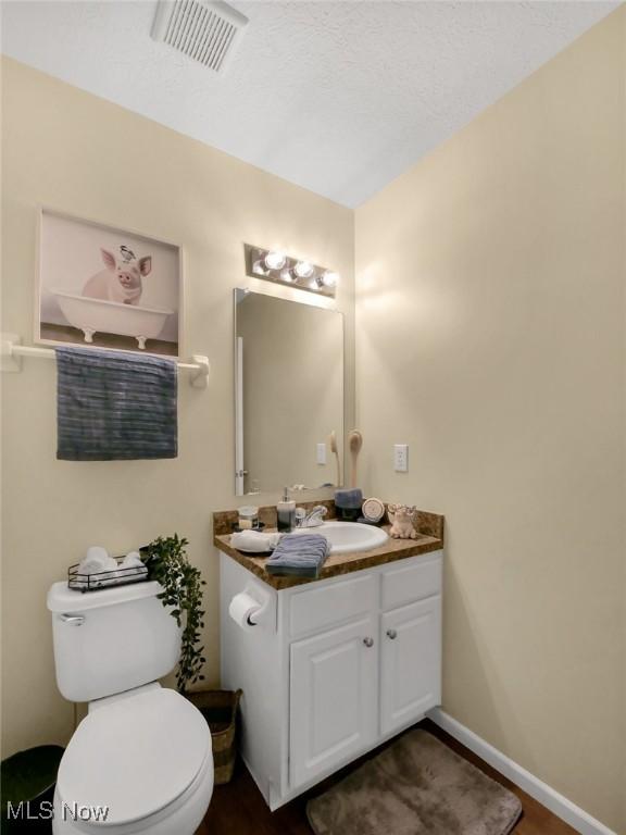 6010 Turnwood Dr, Westerville, OH 43081 - half bathroom featuring vanity, toilet, wood finished floors, and baseboards