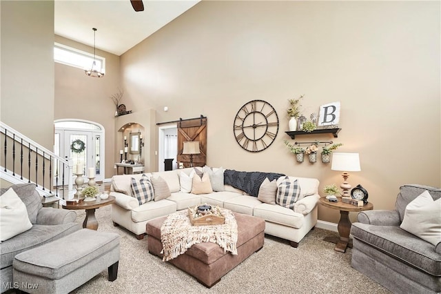 7355 Hunters Glen Ln, Seville, OH 44273 - carpeted living area with stairs, high vaulted ceiling, baseboards, arched walkways, and a barn door