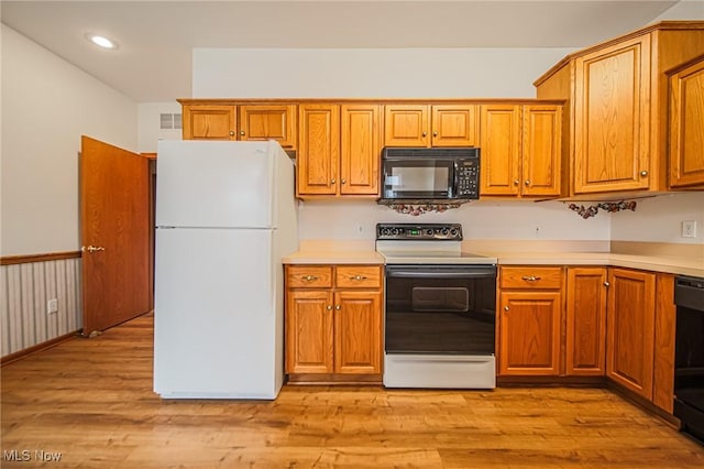 217 Greenbriar Ln, Dalton, OH 44618 - kitchen featuring black appliances, light countertops, brown cabinets, light wood finished floors, and recessed lighting