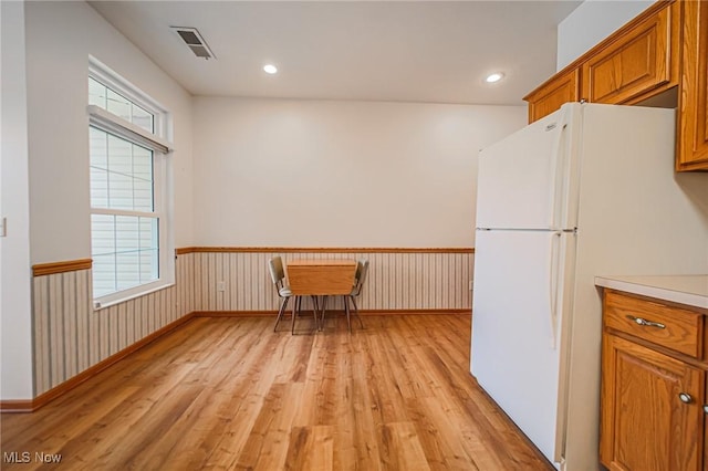217 Greenbriar Ln, Dalton, OH 44618 - kitchen with freestanding refrigerator, light wood finished floors, a wainscoted wall, brown cabinets, and light countertops