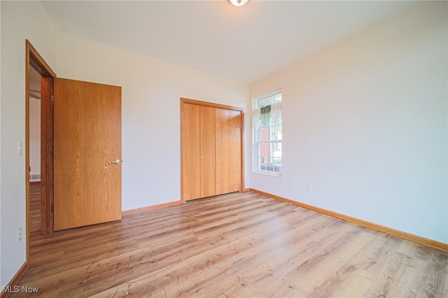 217 Greenbriar Ln, Dalton, OH 44618 - unfurnished bedroom featuring wood finished floors, baseboards, and a closet