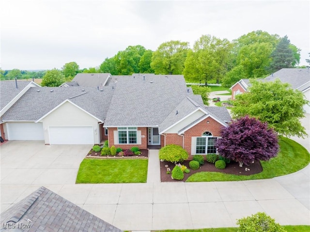 217 Greenbriar Ln, Dalton, OH 44618 - traditional-style house with an attached garage, brick siding, concrete driveway, and a shingled roof