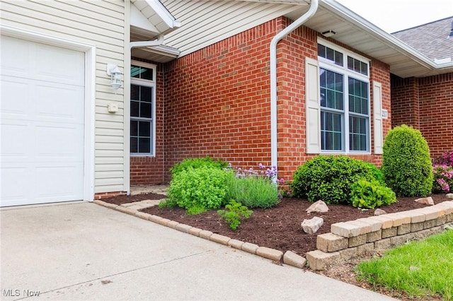 217 Greenbriar Ln, Dalton, OH 44618 - entrance to property with an attached garage, brick siding, and concrete driveway
