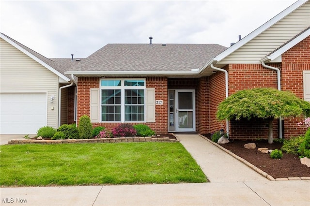 217 Greenbriar Ln, Dalton, OH 44618 - view of front of property featuring brick siding, a front yard, a shingled roof, and an attached garage