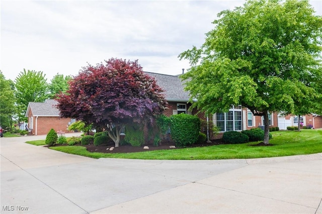 217 Greenbriar Ln, Dalton, OH 44618 - obstructed view of property featuring brick siding, a front lawn, and roof with shingles