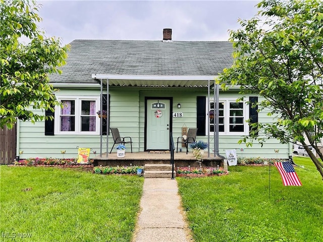 418 Main St, Philo, OH 43771 - view of front of property featuring a shingled roof, a porch, a front yard, and a chimney