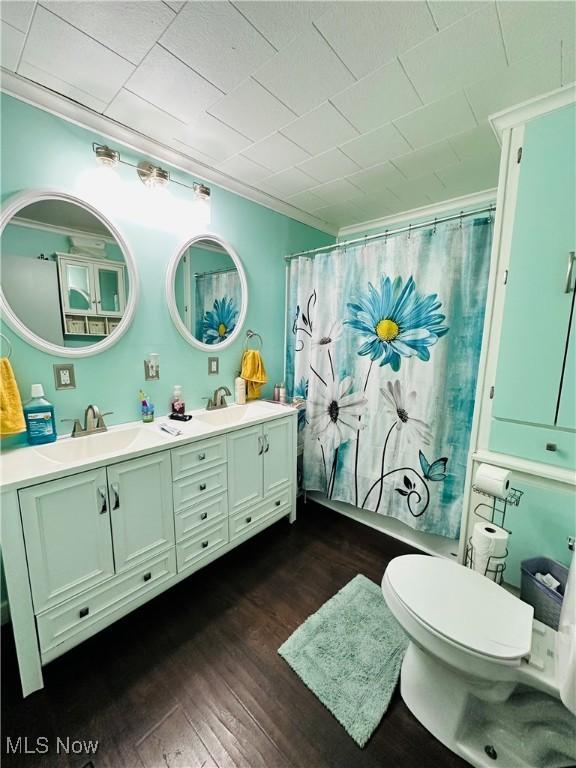 418 Main St, Philo, OH 43771 - bathroom with wood finished floors, double vanity, toilet, and a shower with curtain