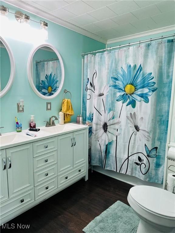 418 Main St, Philo, OH 43771 - bathroom with double vanity, wood finished floors, toilet, and curtained shower