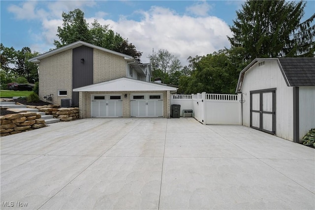 4184 Meadowview Dr NW, Canton, OH 44718 - view of side of home featuring brick siding, a garage, central AC, and a gate