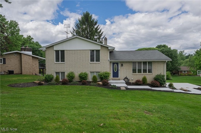 4184 Meadowview Dr NW, Canton, OH 44718 - split level home featuring brick siding, a front yard, a chimney, and central air condition unit