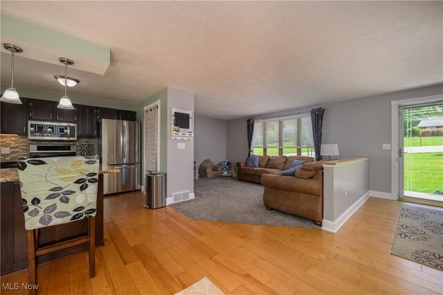 4184 Meadowview Dr NW, Canton, OH 44718 - living room with light wood finished floors, baseboards, and a textured ceiling