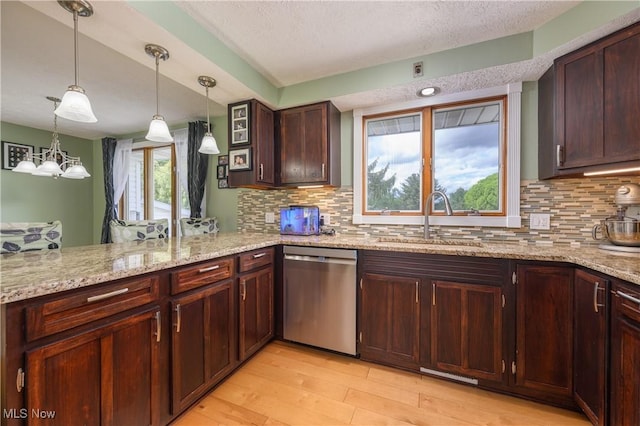 4184 Meadowview Dr NW, Canton, OH 44718 - kitchen featuring stainless steel dishwasher, a sink, light wood-style floors, decorative backsplash, and decorative light fixtures