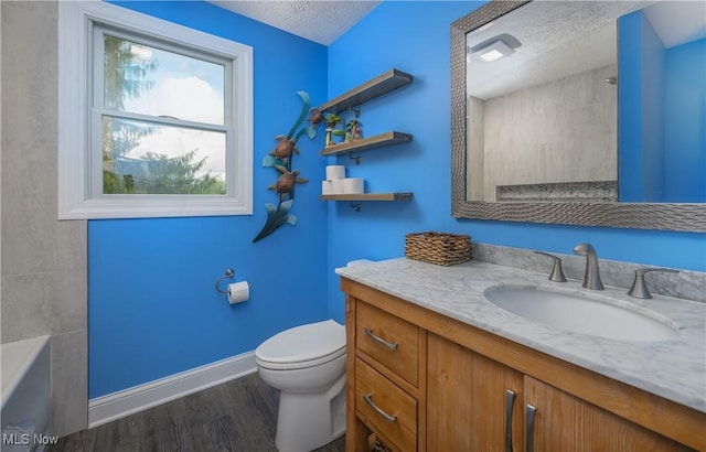 4184 Meadowview Dr NW, Canton, OH 44718 - full bathroom with toilet, vanity, a bath, wood finished floors, and a textured ceiling