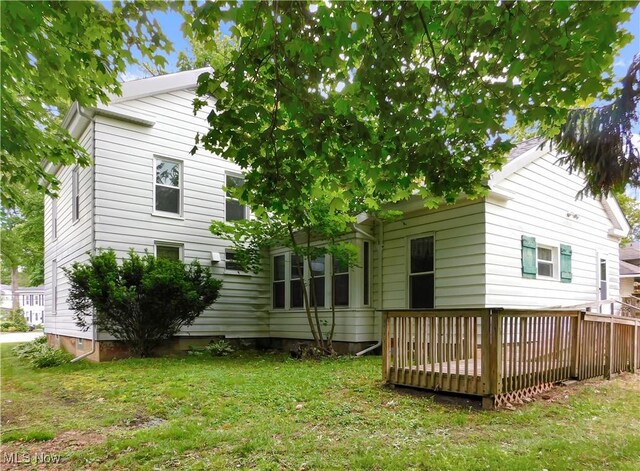 192 Walnut St, Geneva, OH 44041 - back of house featuring a wooden deck and a lawn