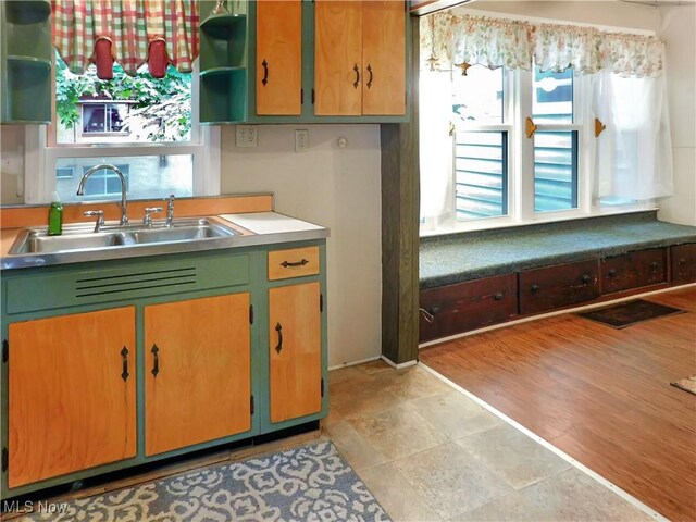 192 Walnut St, Geneva, OH 44041 - kitchen with open shelves, a sink, light countertops, and light stone finish flooring
