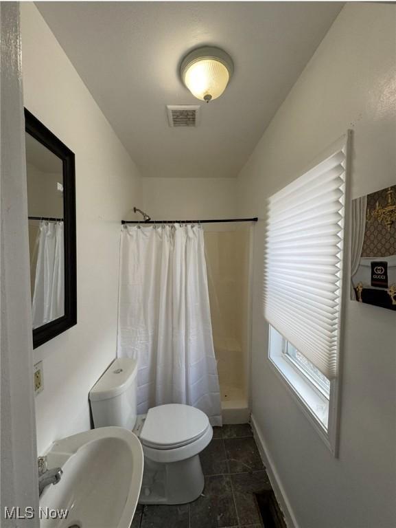 666 Parkwood Rd, Cleveland, OH 44108 - bathroom with toilet, a sink, a shower with shower curtain, baseboards, and tile patterned floors