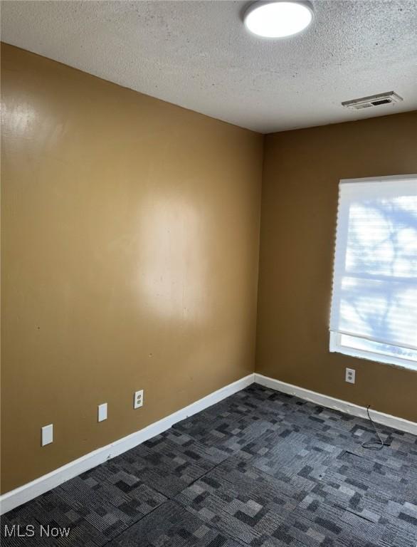 666 Parkwood Rd, Cleveland, OH 44108 - unfurnished room with dark carpet, a textured ceiling, and baseboards