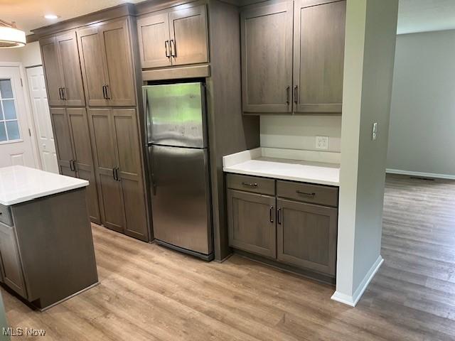 8280 Maple Dr, Chesterland, OH 44026 - kitchen with freestanding refrigerator, light wood-style flooring, baseboards, and recessed lighting