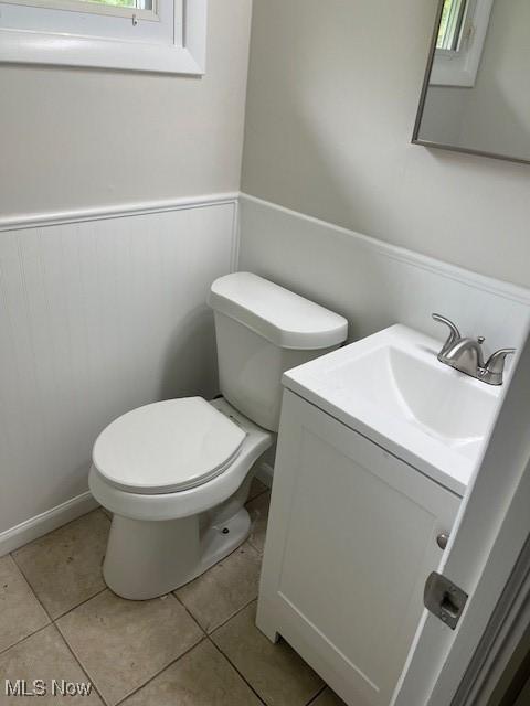 8280 Maple Dr, Chesterland, OH 44026 - half bathroom featuring toilet, vanity, wainscoting, and tile patterned floors