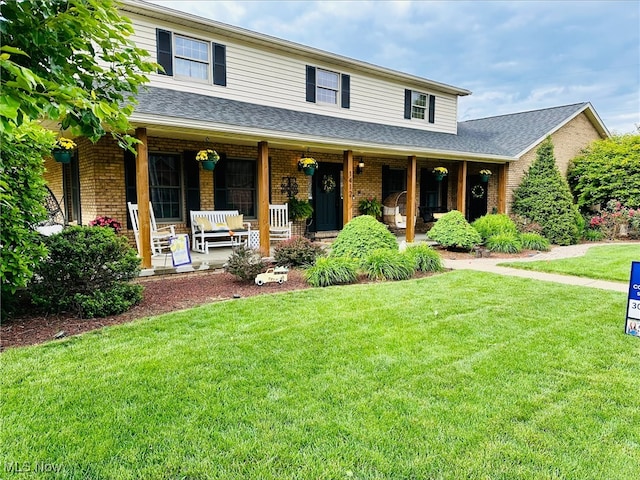 1412 Boulevard Dr, Belpre, OH 45714 - view of front facade with brick siding, a porch, roof with shingles, and a front yard