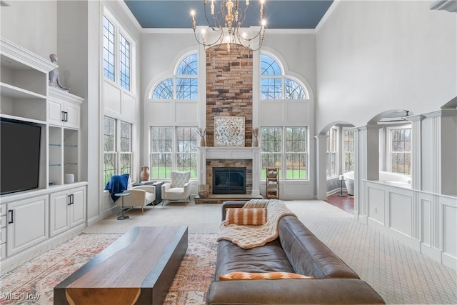 1014 Kings Ridge Blvd, Wadsworth, OH 44281 - carpeted living room with a high ceiling, a chandelier, ornamental molding, arched walkways, and a stone fireplace