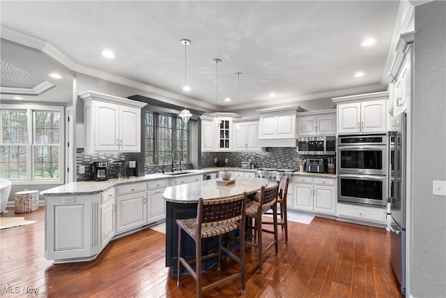 1014 Kings Ridge Blvd, Wadsworth, OH 44281 - kitchen featuring a sink, appliances with stainless steel finishes, crown molding, white cabinets, and a kitchen breakfast bar