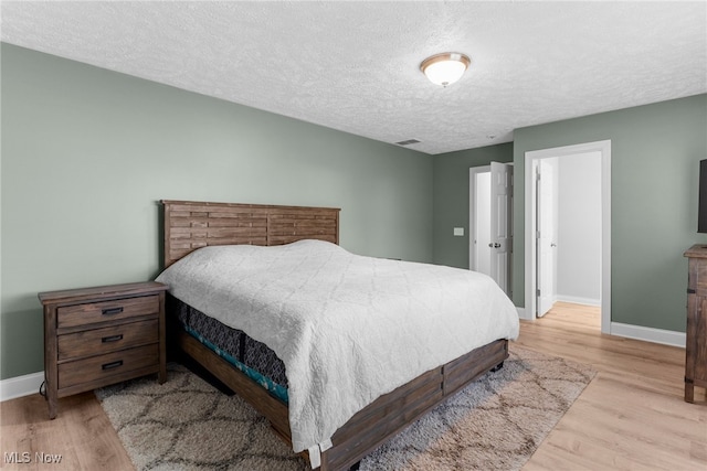 6937 Reynolds Rd, Mentor, OH 44060 - bedroom with baseboards, wood finished floors, and a textured ceiling